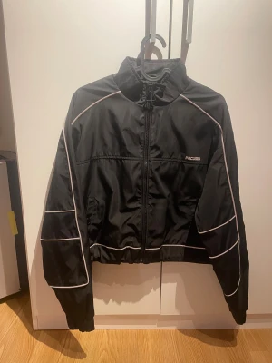 Svart vind/bomber jacka med reflex - En kortare svart vind/bomber jacka med reflexdetaljer och åtdragbar underdel. Aldrig använd☺️