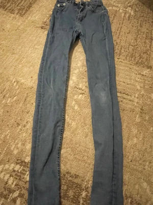 Blå skinny jeans med dragkedja - Snygga blå skinny jeans från 157 med klassisk femficksdesign och dragkedja framtill. Jeansen har en smal passform och är tillverkade i mjukt denimtyg som sitter tajt längs benen. Perfekta för dig som gillar en stilren och enkel look. I storlek xxs, lite skrynkliga därav pris men de ser absolut inte ut så när de sitter på och de är större än vad de ser ut❤️