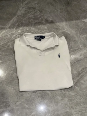 Polo Ralph Lauren Piké - Polo Ralph Lauren Piké  | Vit | Skick: 9/10 | Storlek: M | Pris: 299 SEK | Gratis armband skickas med vid köp (från 31/10) | Priset är diskuterbart | Frakt: Postnord + Instabox + Bring | Skriv vid minsta fråga eller fundering 📩