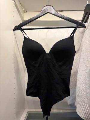 Populära H&M bodyn  - Säljer en svart bodyn med tunna, justerbara axelband och vadderade kupor. Snygg och enkel design med tight passform. Materialet är mjukt och stretchigt. Aldrig använt då den va lite stor på mig. Storlek S. 