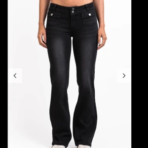 Svarta bootcut jeans med fickdetaljer - Snygga svarta jeans från Madlady med bootcut passform och mellan midja. Jeansen har dubbla knappar framtill, dekorativa ficklock och klassiska bakfickor. Materialet är stretchigt jeans för skön passform och de har en lätt tvättad look. Innerbenslängden 80cm🩷köpta för 699kr