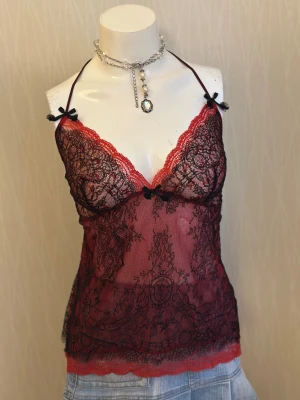 Röd spetsig linnetopp med svarta rosetter - Spets-topp med dubbellager från det välkända märket Chantal Thomass. Ordinarie pris 2000 SEK.