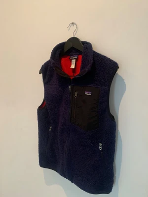 Patagonia väst  - Säljer denna riktigt fina patagoina västen i färgen mörk blå/navy blue.                                                                Den är i bra skick skulle säga 8/10 (inge hål eller liknade alls).                                                                            Den passar dig som vanligtvis använder storlek M-S 
