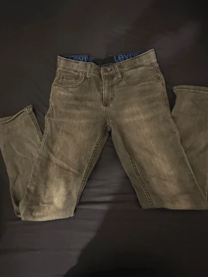 Levi's 511 grå jeans - Snygga grå Levi's 511 jeans med klassisk femficksdesign och Levi's logga på bakfickan. Jeansen har en smal passform och är tillverkade i mjukt jeanstyg. Perfekta för dig som gillar en stilren och modern look.