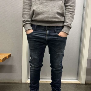 Mörkblå replay jeans - Snygga mörkblå replay jeans i modellen anbass, de är naturligt slitna vid skrevet och knät som gör de speciella. De är i bra skick och storleken w32 l34