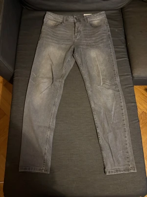 Grå slim jeans från Primark Denim Co - Slim fit jeans i grå tvätt från Primark Denim Co, med stretch för extra komfort. Klassisk femficksmodell och raka ben, tillverkade i bomullsmix. Perfekt för dig som gillar en enkel och stilren look.