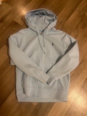 Polo Ralph Lauren Zip ljusblå - Snygg ljusblå zip hoodie från Polo Ralph Lauren cond 8/10 använd fåtal gånger, skickas inom 24h efter betalning 