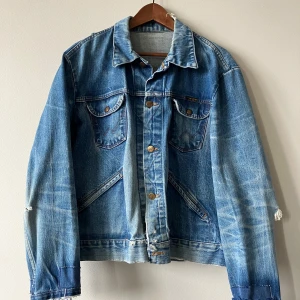 Jeansjacka från Wrangler  - Kolla bara den e hur fet som helst. Skulle säga strl medium, men det finns inga lappar. Det är ju slitningar på den pga gammal, men det är SNYGGT. Skriv om det är nåt, om mått eller så