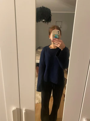 Mörkblå stickad tröja från H&M -  mörkblå stickad tröja från H&M i storlek L. Tröjan har en klassisk rund hals och utsvängda ärmar. Sitter som en M