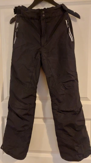 Everest skidbyxor/ täckbyxor strl 152 - Everest skidbyxor/ täckbyxor i strl 152 i smal modell. Bra skick.