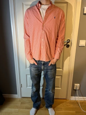 Ralph Lauren skjorta - Säljer en Ralph lauren skjorta i röd rutigt mönster i mycket bra skick inga defekter! Modellen på bilden är 183 och väger 65 kg. Hör av er vid fler frågor!