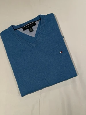 Ljus blå Tommy hilfiger tröja - Ljusblå Tommy Hilfiger-tröja i fint skick. Klassisk och stilren design som passar både till vardag och mer uppklädda tillfällen. Tröjan är väl omhändertagen, utan fläckar eller skador. Postas samma dag vid snabb affär.