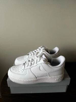 Nike Air Force 1 vita sneakers - Klassiska helvita Nike Air Force 1 sneakers storlek 38,5. Helt nya och oanvända, i perfekt skick. Originalkartong ingår.