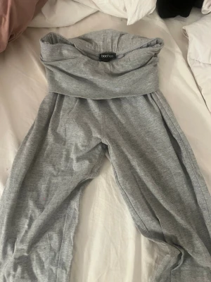 Grå mjukisbyxor från Boohoo - Mysiga grå mjukisbyxor från Boohoo med bred linning och avslappnad passform. Tillverkade i mjukt bomullsmaterial, perfekta för chill dagar hemma eller när du vill vara extra bekväm. Klassisk modell utan synliga detaljer eller mönster. Yoga pants