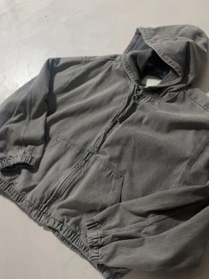 Oversized denimjacka  - En grå denimjacka i oversized passform. Kort i längden och längre och större armar och en luva i herr modell. Bra skick. Storlek L