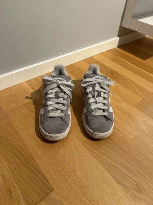 Grå Adidas Campus sneakers  - Snygga grå Adidas Campus sneakers i mocka med vita ränder på sidorna och klassisk Adidas-logga på hälen. Skorna är i fint skick och använda fåtal gånger, pris kan diskuteras och kan gå ner i pris❤️