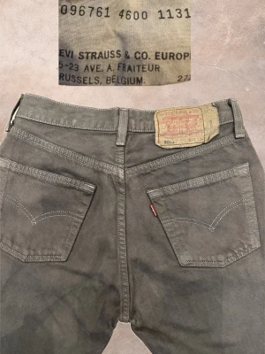 Vintage Bruna Levi's 501 jeans 29x34 - Klassiska grå Levi's 501 jeans med raka ben och femficksmodell. Jeansen har den ikoniska röda Levi's-taggen på bakfickan och patch i midjan. Tillverkade i slitstark bomull, perfekta för en avslappnad och tidlös stil. Mer som 29/32 skulle jag säga..