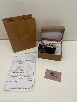 Bälte - Ett reversible bälte i färgen svart och beige med guldig logga. Den är helt ny, är 105 cm lång och det är bara bältet som ingår boxen o allt annat kommer inte med. Pris kan diskuteras och skriv om du har några frågor. 