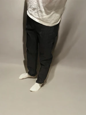 Slim fit jeans från Uniqlo navy - Slim fit jeans från Uniqlo i mörkblått (navy) med klassisk femficksdesign. Materialet är en mix av bomull, polyester och elastan för skön stretch och passform. Snyggt raka ben och stilren look, perfekt för dig som gillar minimalistisk stil. Storleken är W31 L32. Jeansen är nya och har aldrig använts. Skriv om du undrar över något. Kan gå ner i pris vid snabb affär. Passar dig runt 180