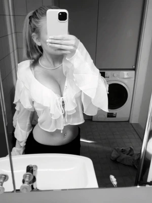 Vit omlottblus med volanger - Säljer en vit blus med omlottknytning och volangdetaljer. Blusen har långa ärmar och djup v-ringning, bara använd en gång 💕Den är XS men passar även i S!💗