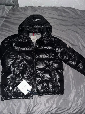 Svart Moncler Jacka  -  Säljer en helt ny och oanvänd svart Moncler-jacka i storlek S. Jackan är i perfekt skick med lappar kvar. Stilren, varm och av hög kvalitet – passar perfekt till både vardag och finare tillfällen.