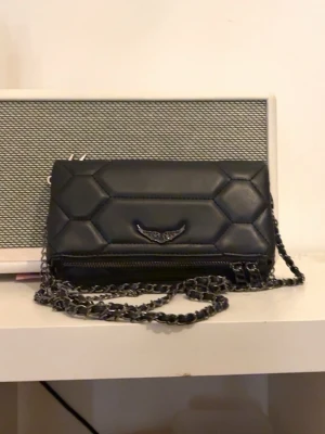 zadig / zadigvoltaire  - Säljer då den ej kommer t användning  Säljer en svart quiltad axelväska från Rebecca Minkoff med coolt hexagonmönster och silverfärgad kedjerem. Väskan har en snygg metallogo framtill och dragkedja längst ner. Perfekt för dig som vill .