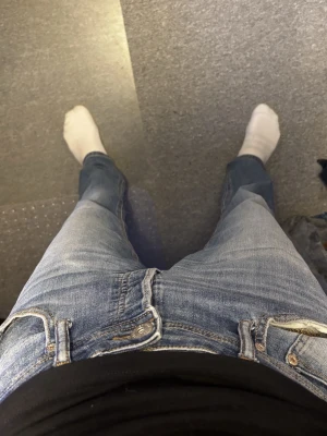 Blå jeans från Jack and Jones - Säljer ett par klassiska blå jeans från jack and Jones med snygga kontrastsömmar på bakfickan. Jeansen har normal passform och raka ben, tillverkade i slitstark denim av bomull. Perfekta för dig som gillar en tidlös och enkel stil.