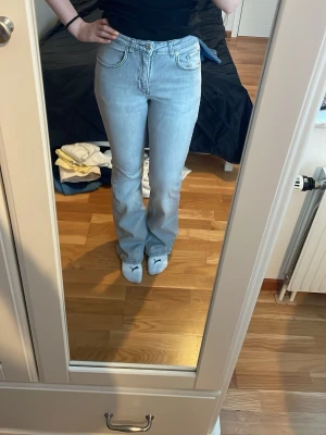 Ljusblå bootcut jeans med hög midja - Säljer ett par ljusblå jeans med bootcut-modell och hög midja. Jeansen har klassiska fem fickor och är tillverkade i mjukt denimtyg. Perfekta för en avslappnad och trendig look. Små slitningar längst ner, men i övrigt i väldigt gott skick💞