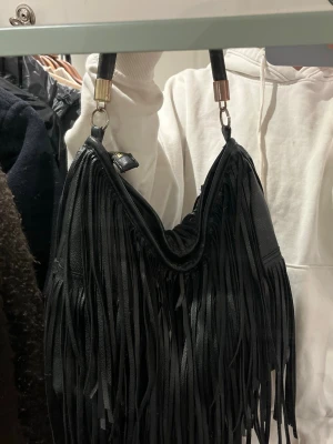 Svart handväska med fransar - Cool men sliten svart handväska i skinn med långa fransar!!! 