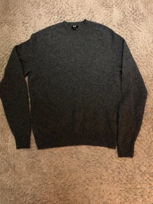 Mörkgrå stickad tröja från Uniqlo - Mörkgrå tröja från uniqlo. Storlek S och är gjord av ull. Längd: 65cm, armhåla till armhåla 47cm, ärmlängd från axel 62 använd ca 10 gånger
