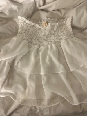 Vit volangkjol från Chelsea - Supersöt vit kortkjol från Chelsea med dubbla volanglager. Perfekt för varma sommardagar. Har knappt kommit till användning 💕