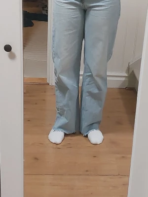 Ljusblå bootcut jeans med rå kant - Snygga ljusblå jea, fransad kant nertill. De har hög midja. Perfekta för dig som gillar en avslappnad men trendig stil. Materialet är klassisk denim. 