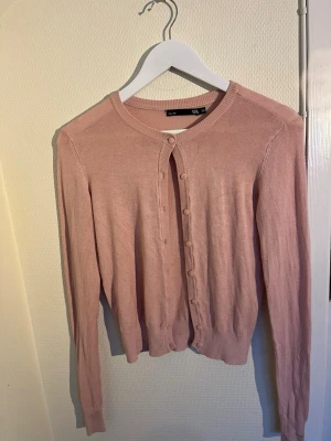 Söt kofta - Söt rosa kofta i storlek XS från Lager 157. Tillverkad i mjuk blandning av 80% viscose och 20% nylon, vilket gör den både skön och följsam. Koftan är nästan som ny och har inga stora tecken på användning. Perfekt för lager-på-lager eller som en färgglad detalj i garderoben! Hör av er vid frågor!☺️
