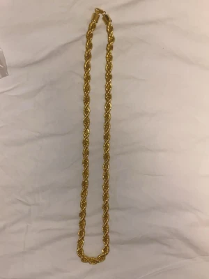 Flätat guldhalsband - Snyggt halsband i guldfärgad metall med flätad design som ger en cool och trendig look. Perfekt för att lyfta vilken outfit som helst med lite extra bling. Halsbandet har ett klassiskt lås och känns rejält utan att vara för tungt.