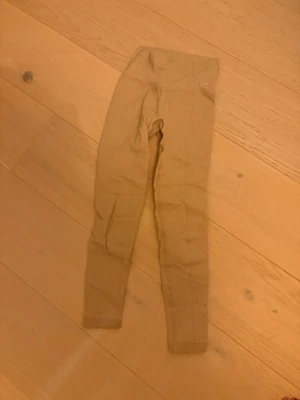 Beige leggings från Aim'n XS - Säljer ett par beige leggings från Aim'n i storlek XS. De har en hög midja och är tillverkade i ett stretchigt material med struktur, bestående av polyamid, polyester och elastan. Perfekta för dig som gillar bekväma och snygga tights.
