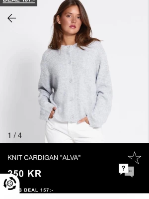 Ljusgrå stickad kofta Alva - Mysig ljusgrå stickad kofta från Alva med rund hals och stora knappar framtill. Koftan har en loose passform och långa ärmar, perfekt att slänga på sig över en t-shirt eller linne.