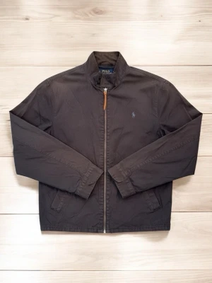 Marinblå Harrington-jacka från Polo Ralph Lauren - Riktigt snygg marinblå Polo Ralph Lauren Harrington-jacka i klassisk modell. En tidlös favorit som passar till det mesta och ger en stilren look året om . Jackan har de rätta detaljerna som ståkrage, diskret logga på bröstet och snygga knäppningar vid ärmsluten och i midjan. Passar runt 183 cm 🙌  Skick: 8/10 ✅ Nypris: ca 2700 Skickar ALLTID inom 48 timmar 🚚 