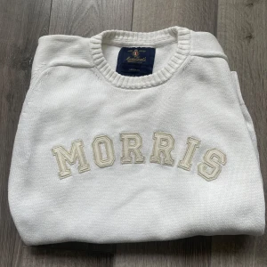 Vit tröja från Morris - Säljer en stilren vit tröja från Morris med broderad text på framsidan. Tröjan har långa ärmar och ribbade muddar vid ärmslut och nederkant. Perfekt för en avslappnad och snygg look. Riktigt snygg tröja inför vår och sommar!  Storlek M Hör av dig vid fundering 🤔 pris är ej hugget i sten 🪨 
