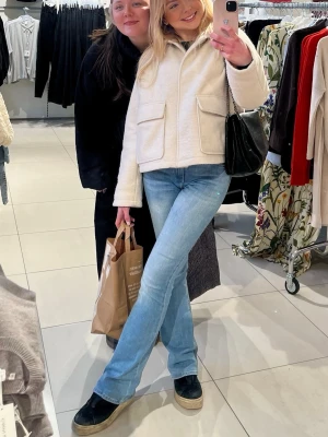 Beige/vit teddyjacka med stora fickor - Beige/vit teddyjacka med krage och två stora fickor framtill. Jackan har en rak passform. Ger en stilren och mysig look. Materialet är mjukt och fluffigt, vilket ger en trendig vibe🐻‍❄️