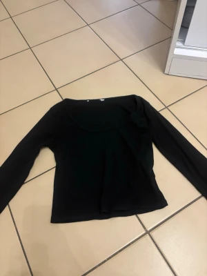 Svart ribbad långärmad topp - Säljer en svart långärmad topp med ribbad struktur och rundad halsringning. Enkel och stilren design som funkar till många olika looks. Materialet är mjukt och stretchigt, perfekt för dig som gillar bekväma plagg med lite edge.