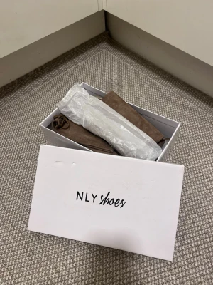 Overknee stövlar i mocka  - Overknee stövlar från NLY Shoes i beige mocka. Stövlarna har platt sula, rund tå och snörning upptill för att sitta perfekt på benet. Storlek: 37 (smala). Mycket bra skick! Säljs på flera sidor, först till kvarn. 