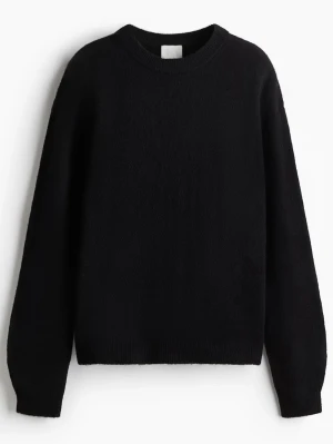 Svart stickad tröja med rund hals - En enkel och stilren svart stickad tröja med rund halsringning och långa ärmar. Perfekt basplagg som funkar till allt och är superenkel att matcha med olika outfits. Hål i tröjan (skriv för bild) därav priset