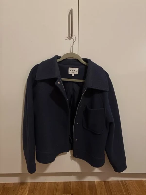 Mörkblå jacka från NA-KD - Säljer den perfekta mörkblå höst / vår jacka från NA-KD med klassisk krage, stora knappar och en rejäl bröstficka. Jackan har en loose passform och passar till vardagliga outfits. Lite nopprig som kan fixas hos kemtvätt 