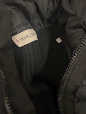 Svart cardigan från Moncler - Säljer en moncler cardigan i storlek L men passar också dig som använder storlek M. Den är i perfekt skick och är använd ansvarsfullt. Priset kan diskuteras!!