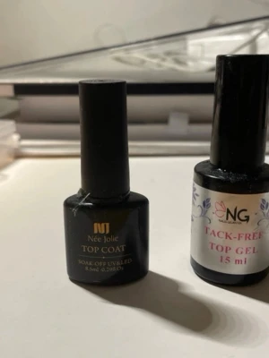 Top gel och top coat för naglar - Två flaskor med top gel och top coat för naglar. NG Nailgarten Tack-Free Top Gel 15 ml med silvrig etikett och svart lock, samt Née Jolie Top Coat 8,5 ml med svart flaska och gulddetaljer. Båda är soak-off och används med UV/LED-lampa. Hälften kvar i båda.