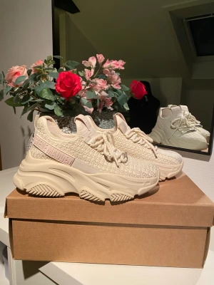 Beige chunky sneakers från Steve Madden - Säljer ett par beige chunky sneakers från Steve Madden med stickad ovandel och grov plattformssula. Skorna har tjocka snören, rund tå och detaljer i syntetmaterial. Märket syns tydligt på sidan och plösen. Perfekt för dig som gillar statement-skor.