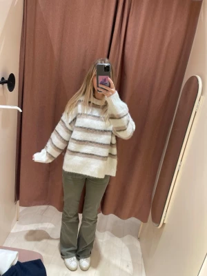 Randig chunky stickad tröja - Helt slutsåld!! Supermysig chunky stickad tröja med breda, suddiga ränder i vitt, beige och brunt. Tröjan har en loose fit, rund halsringning och långa ärmar. Perfekt för lager-på-lager och chill höst- och vinterstil.