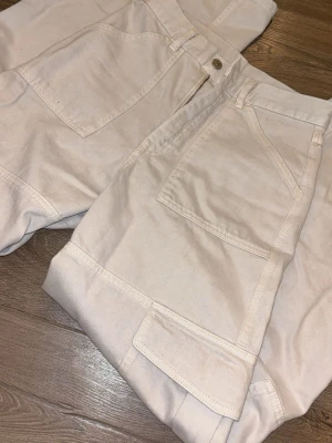 Carin wester high/mid waist beiga cargopants - Säljer dessa eftersom de ej kommer till användning. Ett par beiga cargopants från C.W.  med bred passform och flera stora fickor på både fram- och baksidan. Byxorna har high/mid waist. Byxorna Är tillverkade av bomull och är väldigt mjuka och sköna att bära. Perfekta för dig som gillar streetwear stil. Har används 2-3 gånger Nypris 800kr 💕