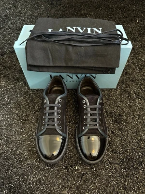Lanvin skor  - Säljer nu ett par sjuka snygga Lanvin! Skicket är väldigt fint, bara en pytteliten defekt på baksida vänster sko (skickar bild privat då det inte får plats i annonsen) Priset är inte hugget i sten vid snabb affär☺️ Box, dustbags och extra snören medföljer. Hör gärna av er om ni har fler frågor!