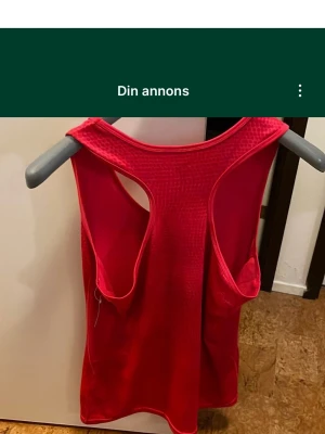 Rött linne från deVal Woman XL - Säljer ett sportigt rött linne från deVal i storlek XL. Linnet har en racerback-design och är tillverkat i ett syntetmaterial med diskret mönster. Perfekt för träning eller aktiva dagar. Snygg och enkel modell med breda axelband. Säljs på fler sidor.